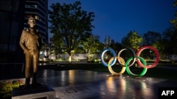 Patung perunggu Pierre de Coubertin (kiri), pendiri Komite Olimpiade Internasional (IOC) dan Cincin Olimpiade di Japan Sport Olympic Square, Tokyo, 20 April 2020.