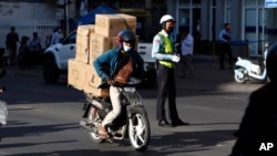 រូបឯកសារ៖ បុរសម្នាក់ដឹកទំនិញតាមម៉ូតូជូនអតិថិជន នៅភ្នំពេញ ថ្ងៃទី ១៩ ខែមករា ឆ្នាំ ២០២២។