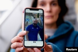 FILE - Oihana Goiriena, wife of journalist Pablo Gonzalez, shows a picture of her husband on her phone, after he was detained by Polish authorities on espionage charges, in Nabarniz, Spain, March 5, 2022.