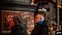 John and Natasha from the US pray during a morning mass at St. Vladimir's Cathedral in Kyiv on March 5, 2022.