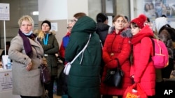 A group of women who fled Russia's invasion of Ukraine wait inside a train station in Zahony, Hungary, March 7, 2022.