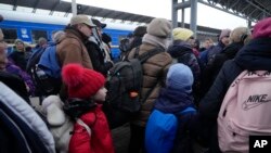 Para orang tua mendampingi anak-anak mereka dalam upaya evakuasi di stasiun kereta api di Kyiv, Ukraina, Senin (7/3). 
