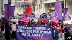Para pengunjuk rasa berbaris dalam aksi protes di dekat istana kepresidenan Malacanang di Manila, Filipina, menandai Hari Perempuan Internasional, Selasa, 8 Maret 2022. (AP/Aaron Favila)
