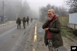 A woman mourns the death of her father, killed by a Russian missile on March 30 near his home on the outskirts of Kyiv, Ukraine, April 1, 2022.
