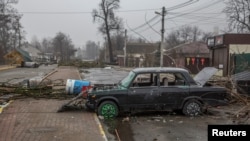 Automobil izbuše mecima na praznoj ulici u Buči, 1. aprila 2022.