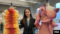 Illene Martoseno berpose dengan dua rancangannya untuk kompetisi desain Supima pada 2019 (VOA Maret 2022)