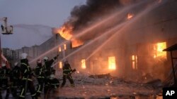 Ukrainian firefighters extinguish a blaze at a warehouse after a bombing in Kyiv, March 17, 2022. 