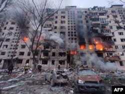In this handout picture taken and released by the State Emergency Service of Ukraine on March 14, 2022, firemen work to extinguish a fire in an apartment building hit by shelling in the Obolon district of Kyiv.