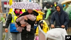 抱着孩子走在波兰梅迪卡过境点的乌克兰难民。(2022年4月1日)