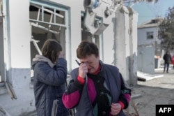 Nurses cry as they arrive to see their hospital after Russian shelling hit the mental hospital of Mykolaiv, southern Ukraine, March 22, 2022.
