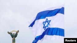 ILUSTRASI - Bendera Israel yang ditempelkan pada drone (tidak terlihat) berkibar di samping Monumen Kemerdekaan di Kyiv, Ukraina, 14 Mei 2021. (REUTERS/Valentyn Ogirenko)