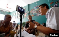 រូប​ឯកសារ៖ អ្នក​កាសែត​និង​ជា​សកម្មជន​សិទ្ធិមនុស្ស​លោក Le Van Dung ធ្វើ​ការ​ផ្សាយផ្ទាល់​តាម​ហ្វេសប៊ុក​ពី​ហាង​កាហ្វេ​មួយ​នៅ​ទី​ក្រុង​ហាណូយ​ប្រទេស​វៀតណាម​កាល​ពី​ថ្ងៃ​ទី​១៥ ខែ​ឧសភា ឆ្នាំ​២០១៨។