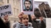 FILE - A protester holds a photo depicting Russian President Vladimir Putin as Adolf Hitler during a demonstration against Russia's invasion of the Ukraine, in Skopje, North Macedonia, March 6, 2022.