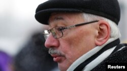 FILE - Oleg Orlov, a Memorial board member, speaks to the media outside the Moscow City Court building during a hearing to consider the closure of the Memorial human rights center in Moscow, December 29, 2021.