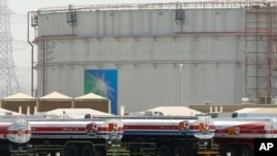 Truk bahan bakar berbaris di depan tangki penyimpanan di pabrik curah Jeddah Utara, fasilitas minyak Aramco, di Jeddah, Arab Saudi, pada 21 Maret 2021. (Foto: AP)