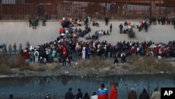 FILE - Migrants gather at a crossing into El Paso, Texas, as seen from Ciudad Juarez, Mexico, Dec. 20, 2022. The Biden administration on Jan. 5, 2023, said it would immediately begin turning away Cubans, Haitians and Nicaraguans who cross the U.S.-Mexico border illegally, a major expansion of an existing effort to stop Venezuelans attempting to enter the U.S.