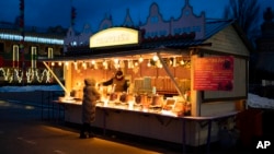 A Ukrainian man serves hot mulled wine during the Orthodox Christmas Eve in Kyiv, Ukraine, Jan. 6, 2023. 