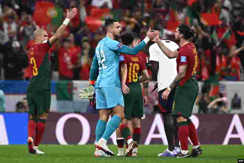 Moyambi ya Portugal #22 Diogo Costa (C) azali kosepela na milieu #18 Ruben Neves ya ekipiki na ye na match na Suisse na 8e ya Mondial Qatar na stade Luasil, Doha, 5 décembre 2022. (Photo by Fabrice COFFRINI / AFP)