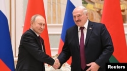 Russian President Vladimir Putin shakes hands with Belarusian President Alexander Lukashenko during a news conference following their meeting in Minsk, Belarus December 19, 2022. (Pavel Bednyakov/Sputnik/Kremlin)