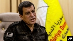 FILE - Syrian-Kurdish commander Mazloum Abdi of the U.S.-backed Syrian Democratic Forces speaks during a news conference in Hasakah, Syria, Nov. 26, 2022. 