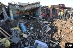 Ukrainian rescuers work on the site following a Russian missile strike on a local market in Shevchenkove village, Kharkiv region, Jan. 9, 2023.