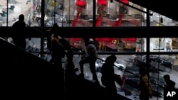 购物者黑色星期五在纽约一家耐克商店乘电梯上下（2022年11月25日）