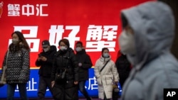 北京民众走出朝阳区CBD金融区的一个地铁站。（2023年1月12日）