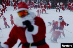 Para pemain ski berpakaian Sinterklas berpartisipasi dalam acara amal Santa Sunday di resor ski Sunday River di Bethel, Maine, AS, 5 Desember 2021. REUTERS/Brian Snyder