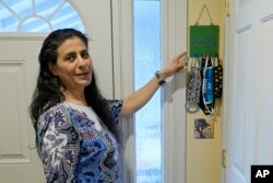 Koloud Kej Tarapolsi pokazuje na držač za maske koji je napravila njena ćerka i na kome je na arapskom napisana fraza "Za vaše zdravlje", u njenom domu u Redmondu, u državi Vašington. (Foto: AP/Ted S. Warren)