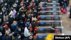 Warga China bergegas mengejar kereta di stasiun kereta api di Suzhou di Provinsi Jiangsu, China timur, Sabtu, 7 Januari 2023. (Foto: Xinhua via AP)
