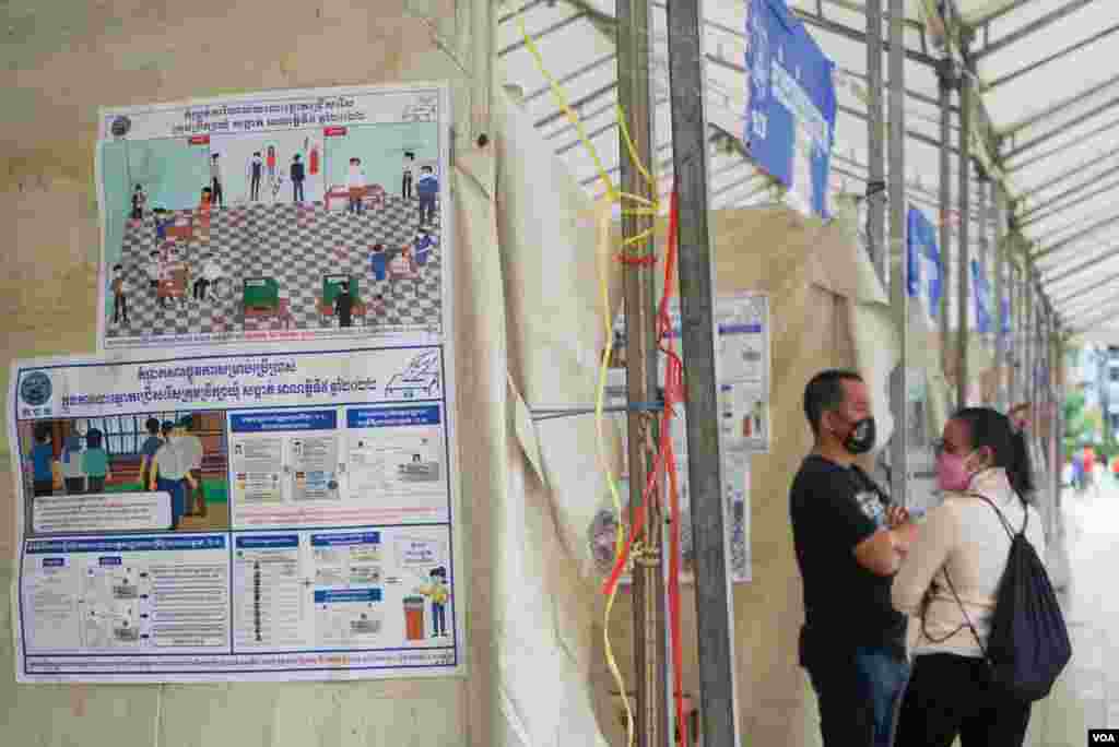 ពលរដ្ឋពិនិត្យមើលបន្ទប់បោះឆ្នោតរបស់មណ្ឌលបោះឆ្នោតមួយកន្លែង មួយថ្ងៃមុនការបោះឆ្នោតឃុំសង្កាត់អាណត្តិទី ៥ ក្នុងសង្កាត់ផ្សារកណ្តាលទី ២ ខណ្ឌដូនពេញ ភ្នំពេញ ថ្ងៃសៅរ៍ ទី ៤ ខែមិថុនា ឆ្នាំ ២០២២។ (ខាន់ សុគុំមនោ/វីអូអេ)