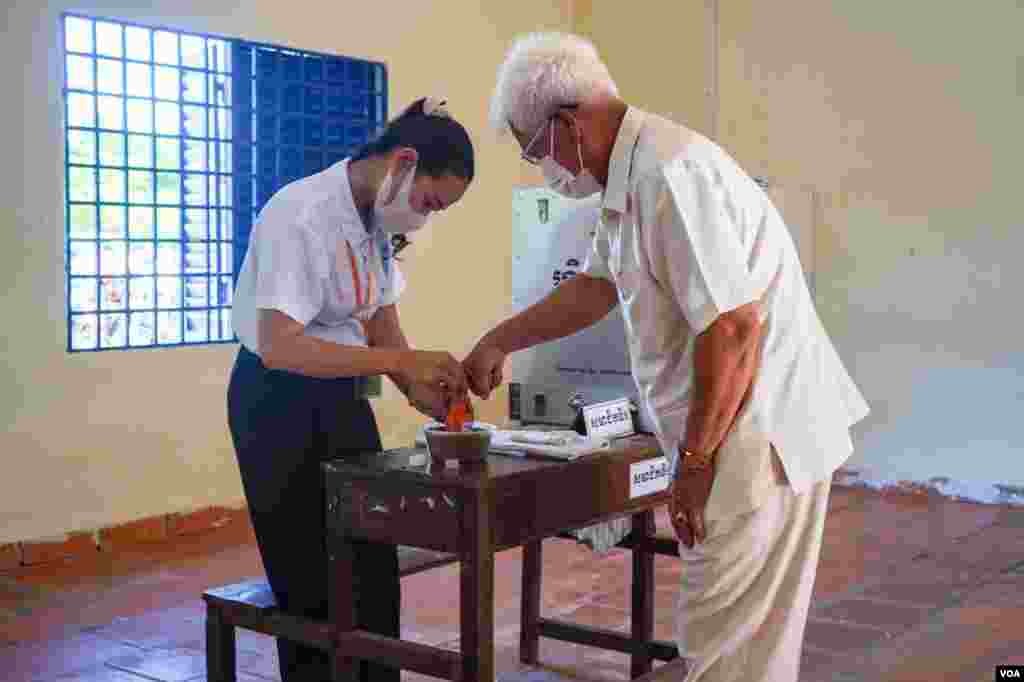 ពលរដ្ឋម្នាក់ជ្រលក់ម្រាមដៃក្នុងទឹកថ្នាំក្រោយពីបានបោះឆ្នោតហើយ ក្នុងការបោះឆ្នោតជ្រើសតាំងក្រុមប្រឹក្សាឃុំសង្កាត់អាណត្តិទី ៥ នៅក្នុងសង្កាត់ភ្នំពេញថ្មី ខណ្ឌសែនសុខ រាជធានីភ្នំពេញ ថ្ងៃទី ៥ ខែមិថុនា ឆ្នាំ ២០២២។ (ខាន់ សុគុំមនោ/វីអូអេ)