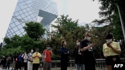 人们在北京的央视大楼旁排队等候进行新冠核酸检测。（2022年6月13日）