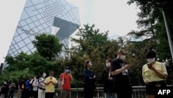 人们在北京的央视大楼旁排队等候进行新冠核酸检测。（2022年6月13日）