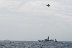 Pesawat tempur F-16 milik TNI AU terbang melintas di atas kapal perang TNI AL dalam operasi di Natuna, di dekat Laut China Selatan, Indonesia, 10 Januari 2020. (Foto: Risyal Hidayat/Antara via Reuters)