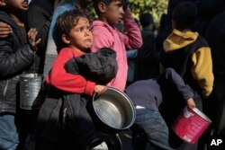 Palestinian children queue for food in Deir al-Balah, Gaza Strip, on Dec. 13, 2024.