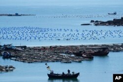 Sebuah perahu bergerak di titik terdekat daratan China ke pulau Taiwan, di Pingtan di Provinsi Fujian, China tenggara, 5 Agustus 2022. (Foto: AP)