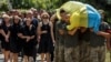 Ukrainian servicemen carry a coffin with the body of their brother-in-arms Vitalii Petiushko, who was recently killed in a fight with Russian troops, as Russia's attack on Ukraine continues, during a funeral ceremony in Uzhhorod, Ukraine, on August 8, 2022. 