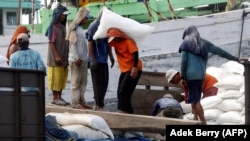 Pekerja memuat karung pupuk di sebuah pelabuhan di Jakarta, 7 Desember 2007. (Foto: AFP/Adek Berry)