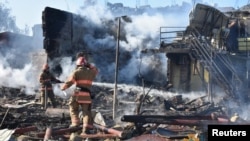 Firefighters work in a residential area damaged by a Russian missile strike in the settlement of Zatoka, Odesa region, Ukraine July 26, 2022, in this photo provided by the State Emergency Service of Ukraine.