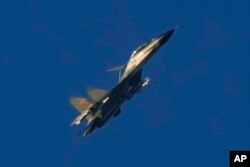 资料照片：2022年8月5日，一架中国J-11军用战斗机飞越台湾海峡附近的福建省平潭。