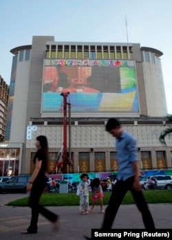 Orang-orang berjalan di depan kasino NagaWorld di pusat kota Phnom Penh, 11 Januari 2014. (Foto: REUTERS/Samrang Pring)