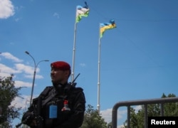 FILE - An Uzbek service member guards a road in Nukus, capital of the northwestern Karakalpakstan region, Uzbekistan, July 6, 2022.