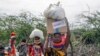 Locals residents carry boxes and sacks of food distributed by the United States Agency for International Development (USAID), in Kachoda, Turkana area, northern Kenya, July 23, 2022.
(AP Photo/Desmond Tiro)