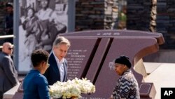 Menteri Luar Negeri AS Antony Blinken dan Antoinette Sithole (kanan), saudara dari mendiang Hector Pieterson, meletakkan karangan bunga di monumen Hector Pieterson di Soweto, Afrika Selatan, pada 7 Agustus 2022. (Foto: AP/Andrew Harnik)
