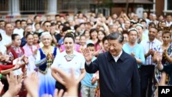 Dalam foto yang dirilis oleh Kantor Berita Xinhua China, Presiden China Xi Jinping (tengah), mengunjungi komunitas Guyuanxiang di Distrik Tianshan, Urumqi, Daerah Otonomi Uyghur Xinjiang, China barat laut, Rabu, 13 Juli 2022. (Yan Yan/Xinhua via AP )