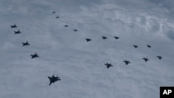 FILE - In this photo provided by South Korea Defense Ministry, US and South Korean fighter jets fly in formation during a joint drill, June, 7, 2022. 