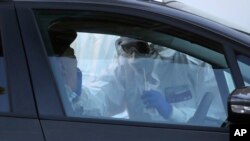 Medical staff of a mobile unit take samples from a man to test for COVID-19, at Italy's Santa Maria della Pieta' hospital complex on April 3, 2020. 