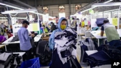 FILE - Garment factory employees work at Arrival Fashion Ltd. in Gazipur, Bangladesh, March 13, 2021.