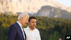 资料：2022年6月26日，美国总统拜登和法国总统马克龙在德国出席七国集团峰会时交谈。（美联社照片）